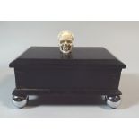 An Early 20th Century Art Deco Ebony Stamp Box with Skull Finial and Supported on Chrome Ball Feet.