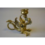 A Decorated Brass Novelty Candlestick in the Form of a Dragon with Coiled Trail. 11.5cm Long.