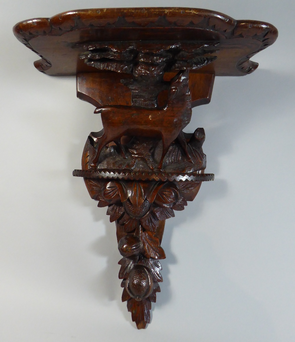 A Black Forest Wall Shelf with Carved Decoration depicting Walnuts and Female Red Deer Beside Tree.