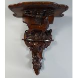 A Black Forest Wall Shelf with Carved Decoration depicting Walnuts and Female Red Deer Beside Tree.
