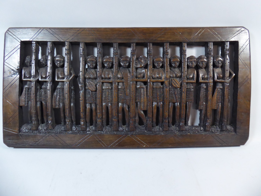 A Carved Wooden African Panel Depicting Twelve Topless Maidens Behind Bars.