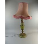 A Brass and Onyx Table Lamp with Seated Cherub Mounts and Pink Shade