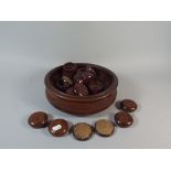 A Turned Oak Fruit Bowl with Three Bun Feet Containing Furniture Caster Stands