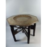 An Early 20th Century Anglo Indian Carved Wood Folding Coffee Table with Hexagonal Brass Top.