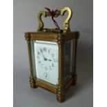 A French Brass Carriage Clock with Pierced Gilt Panels, White Enamel Dial with Alarm Subsidiary.