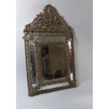 A 19th Century Dutch Brass Cushion Framed Wall Mirror with Bevelled Plate and Scroll Crest. 66c38.