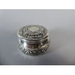 A Small Silver Lidded Pot with Embossed Swags and Foliate Decoration.