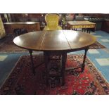 A Titchmarsh Style Oak Drop Leaf Gate Leg Table with Oval Top on Turned Supports. 105x37.