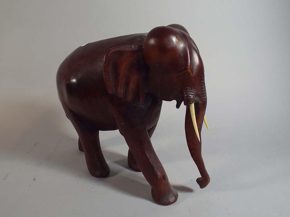 A Carved Wooden Study of an Elephant, One Tusk Glued,