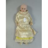 A Victorian Bisque Head Doll with Composition Arms and Legs.