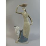 A Lladro Matt Figure Group of Girl with Bowl of Fruit on Her Head, Stood Beside Goat.
