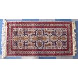 A Patterned Woven Woollen Rug on Fawn Ground.