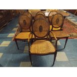 A Set of Eight Walnut Framed Dining Chairs with Oval Cane Backs and Cane Seats,