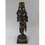 An 18th Century Bronze Figural Candlestick in the Form of a Cherub Supporting Vase on Head.