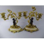 A Pair of Early Continental Gilt Bronze Two Branch Figural Candlesticks with Seated Cherub Sat on