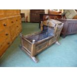 A Continental Panelled Rocking Crib with Hinged Top Having Carved Birds Head Finial.