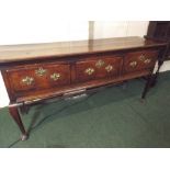 An Early Oak Dresser Base Having Three Crossbanded Drawers all with Brass Handles and Escutcheons.
