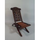 A 19th Century Anglo Indian Padouk Wood Folding Campaign Chair with a Profusely Carved and Pierced