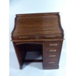 An Edwardian Oak Roll Top Kneehole Desk with Fitted Interior and One Base Bank of Four Graduated