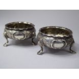 A Pair of Georgian Silver Salts with Embossed Floral Decoration. Wavy rims and on Tripod Pad Feet.