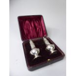 An Edwardian Cased Pair of Silver Pepper pots,