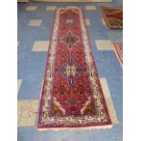 A Nice Quality Patterned Woollen Runner on Red Ground,