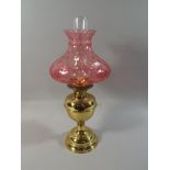 A Brass Oil Lamp with Coloured Glass Shade,