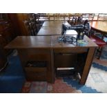 An Edwardian Oak Treadle Singer Sewing Machine with Fitted Cabinet