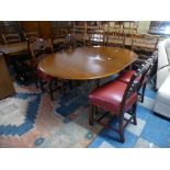 An Extending Mahogany Oval Topped Dining Table and Four Carved Oak Framed Ladder Back Chairs