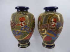 A Pair of Japanese Satsuma Vases, depicting various characters and signed to base, approx 26 cms