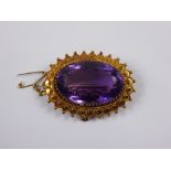 An Edwardian 15 ct Gold and Amethyst Brooch. The amethyst set in a disc and beaded mount, the