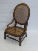 An Oak Oval Back Nursery Chair, with rush seating.