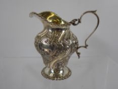 A Solid Silver Cream Jug, the jug of floral design, Edinburgh hallmark dd 1905, mm H&J. approx 200