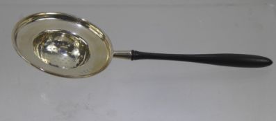 A Silver Tea Strainer, with ebonized handle, Sheffield hallmark, mm Walker & Hall, dated 1910,