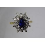 A Lady's 18 ct Yellow and White Gold Sapphire and Diamond Ring, the sapphire 7.7 x 5 mm, 8 x round