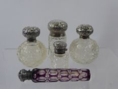 Four Cut Glass and Silver Perfume Bottles together with a lilac faceted scent bottle. (5)