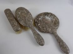 A Solid Silver Dressing Table Set Depicting Doves, including hand mirror, hair brush and clothes