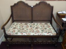 A Mahogany Framed Double Bergère Settee, with cane back and seating, decorative carving to the