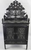 An Antique Ebony Chinese Jewellery Cabinet, with decorative carving to door and drawer fronts, two