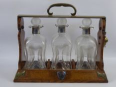 A Silver Collared Decanter Tantalus, with three ribbed shaped glass decanters and stoppers, London
