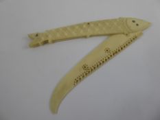 An Antique Ivory Folding Letter Opener, in the form of a fish, the fish having scrimshaw eyes,