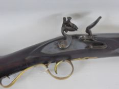 An Antique Flintlock Musket, the musket having a polished brass trigger guard, butt plate, ramrod