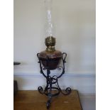 An Antique Copper and Brass Oil Lamp, held within a wrought iron support, approx 66 cms