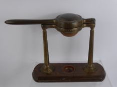 A Vintage W. Thornhill & Co Brass Citrus Press, supported on an oak base.