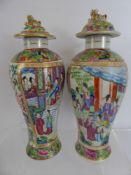 A Pair of Cantonese Vases and Covers, depicting scenes of leisure approx 30 cms high.