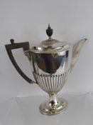A Solid Silver Coffee Pot, the pot having a ribbed body, spout and lid with ebonised handle and