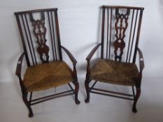 A Pair of Arts & Crafts Hall Elbow Chairs, with rush seating.