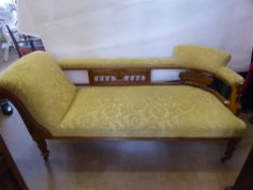 A Oak Framed Edwardian Chaise Longue, yellow damask style upholstery, raised on turned legs.
