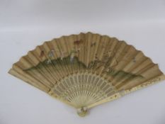 A 19th Century Chinese Paper and Ivory Fan, hand painted with figures in a garden feeding birds,