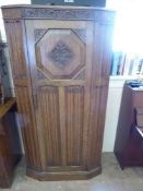 An Edwardian Solid Oak Wardrobe, with decorative carving to door panel.